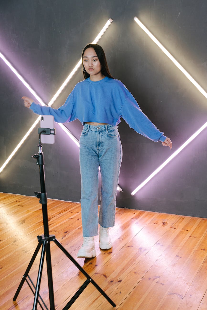 a young woman filming while dancing